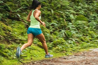 Woman running on a dirt road.