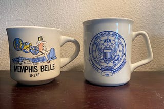 Two coffee cups from Navy Commands.