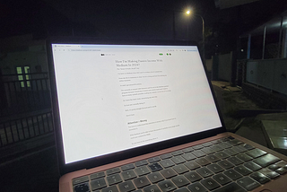 Laptop with a Medium article open at night outside.