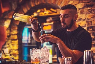 A bartender prepares a mixed drink.