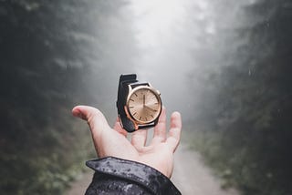 A man’s hand tossing a watch into the air for my article, Does Anyone Still Wear a Watch?