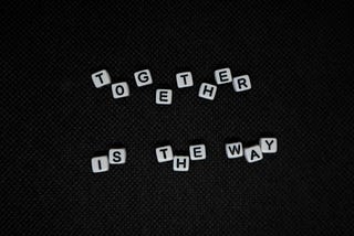 A black background. On the background is white blocks, with black letters on them. The blocks make up the words ‘Together is the way’. Photo by Margarida Afonso on Unsplash: https://unsplash.com/s/photos/team?utm_source=unsplash&utm_medium=referral&utm_content=creditCopyText