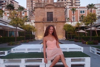 In Spain, sitting by the port ith a small chapel behind me.