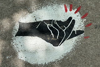 Sidewalk art of a snapping black hand in a white background