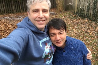 Eli and Sean taking a selfie together. Sean is wearing an other bothers sweatshirt and Eli a blue sweater.