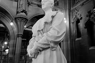 Black and white photo of a statue of Enriqueta Augustina Rylands at the John Rylands library, Manchester