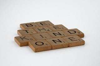 scrabble tiles spelling out be the kind one