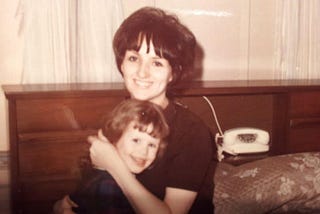 Young woman holding a little girl on her lap 1960's