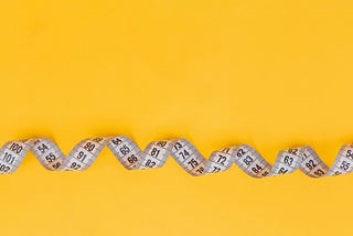 measuring tape on a yellow background representing accuracy measurement of machine learning models