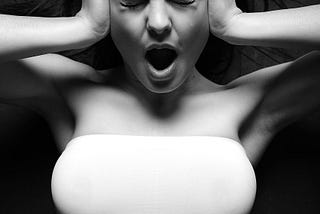 Monochrome image, young woman, hands on the side of her head, scream, anguish, frustration
