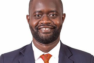 Photo of Von Onyango in suit and tie and smiling