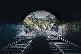 A person walking out of a tunnel.