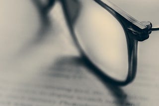 A pair of glasses sits on top of a law textbook.