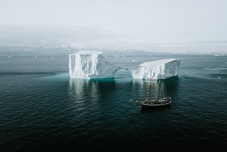Boat floating by icebergs