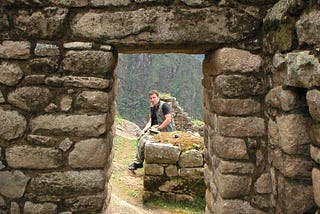 white guy sitting at Machu Picchu