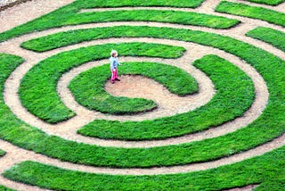 A young child is at the center of a labyrinth.