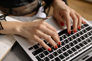 Woman’s hands typing on laptop keyboard