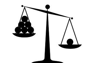 Image of a scale. One side has one ball and is weighed down. The other side has five balls and is not weighed down as much.