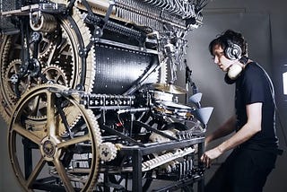 Martin Molin performing on the Wintergatan Marble Machine, a large wooden instrument powered by gears, cranks, and cascading marbles.