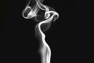 A black and white image showing smoke coming from a lid match