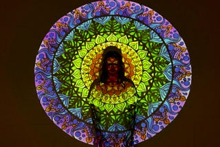 Woman in green and purple ceramic mandala on black background