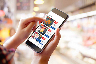 Image of a person using the Lidl Plus app on their smartphone while browsing exclusive discount.