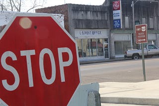 stop sign in front of US Post Office building