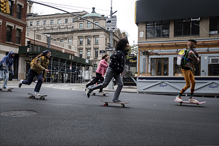In a still from Betty, Camille, Indigo, Honeybear, and two friends ride their skateboards down a New York City street.