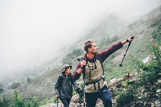 A photo of two people hiking on a mountain.