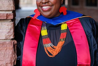 Shamika Klassen close up with graduation regalia and African inspired jewelry