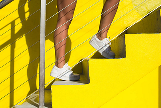 Close-up shot of Person’s Legs Standing on Yellow Stairs. How stair climbing transforms your heart health and body composition