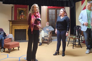 Five actors on the stage in rehearsal