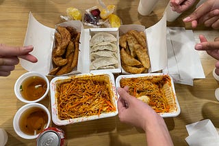 Noodles and dumplings takeaway with finger hearts around