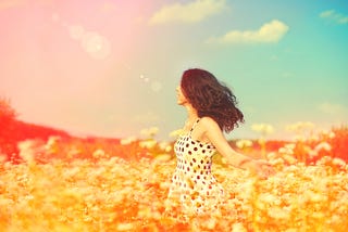 Happy and free woman walking in a field