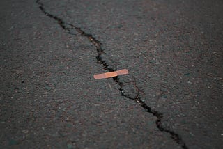 a bandaid over a crack in asphalt