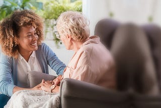 home health aide offers companionship to senior woman at home