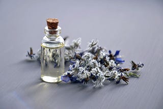 clear glass bottle next to dried blue flowers