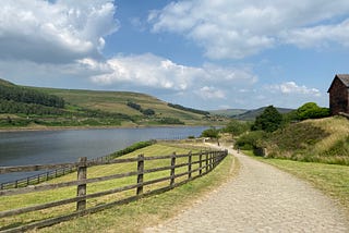 Wide cobbled bridleway above a reservoir on the Trans-Pennine Trail