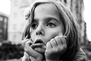 A fed-up looking little girl in black and white