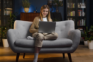 Image of a girl sitting on the sofa and using a laptop with NBN.