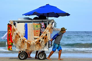 Hawker pulling a cart on the beach