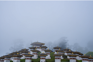 a set of short square columns on a hillside in the fog