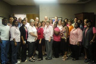 A group of people gathered to observe Breast Cancer Awareness Month