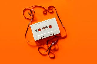 1980’s unravelled cassette tape on a bright orange background