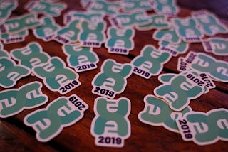 Table full of HealthHack 2019 Stickers.