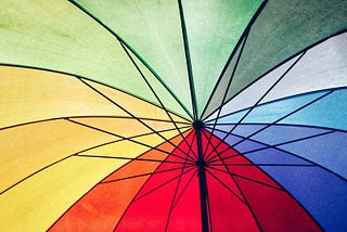 Um guarda-chuva com tons de vermelho, amarelo, verde e azul. Fonte: http://blog.allbags.com.br/2019/04/15/cores-astral/