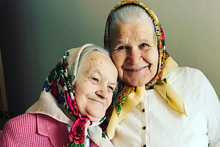 Two grandmas in headscarves smiling