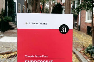 A photo of the book Expressive Design Systems in front of a street scene