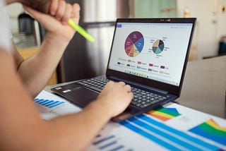 A man using a laptop for financial work.