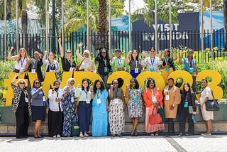 A group women in front of the WD2023 sign in Kigali